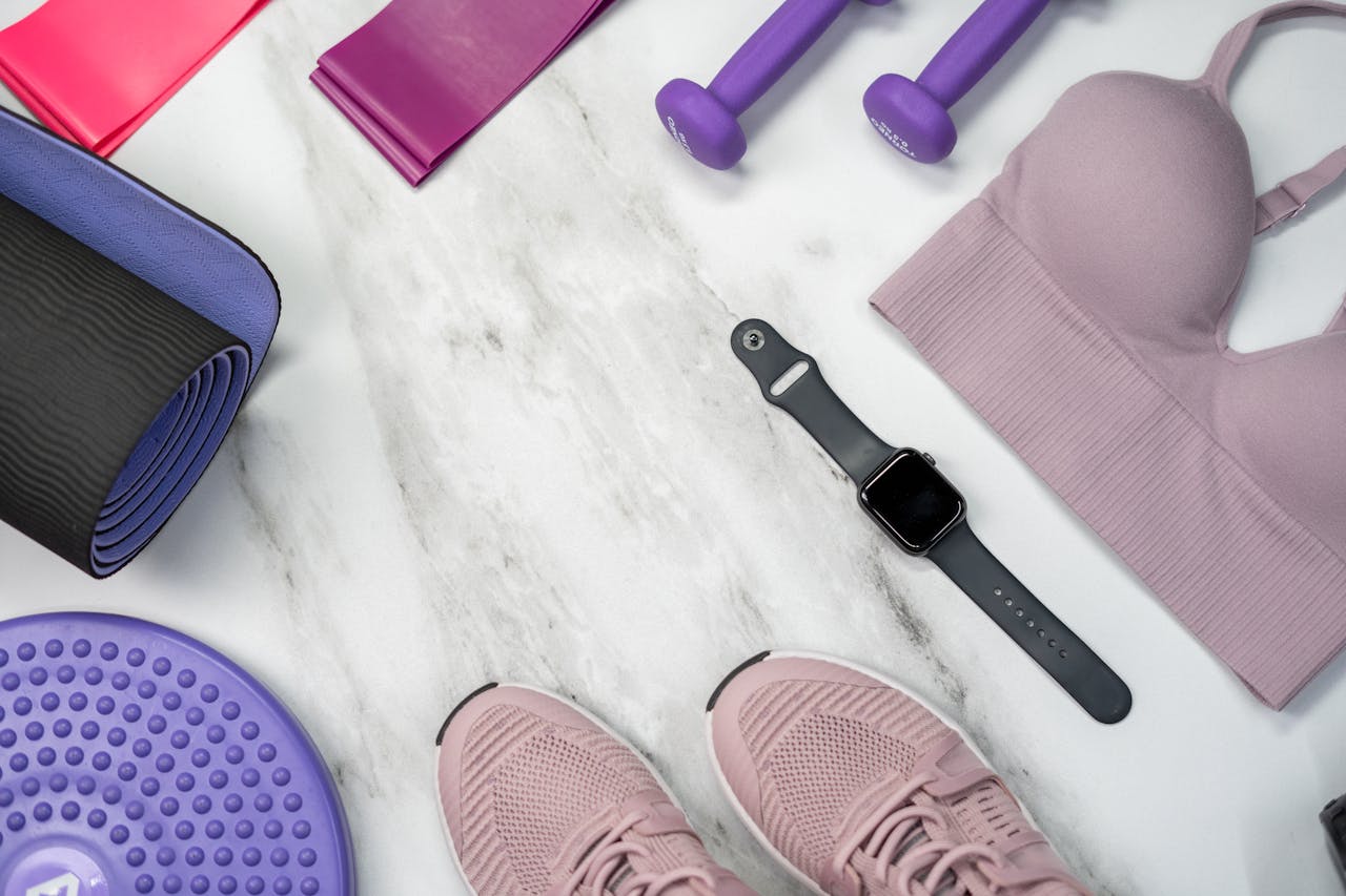 services-03 Flat lay of fitness gear including yoga mat, dumbbells, and smartwatch on a marble surface.